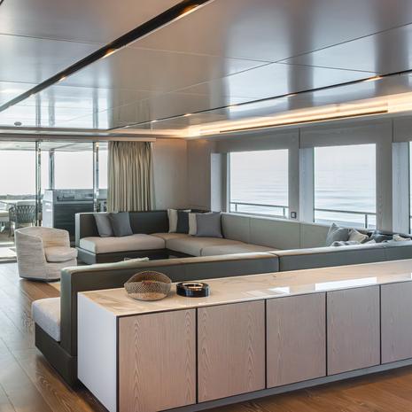 Explorer yacht Mitan main saloon with L-shaped grey sofa