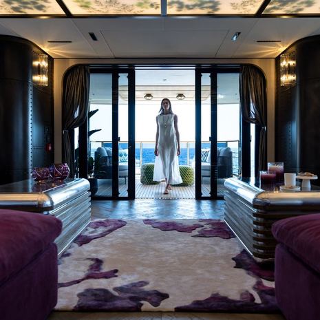 woman in Sirena 118 Superyacht IKIGAI main salon between purple seating