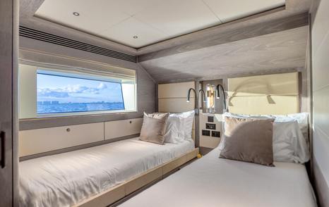 Motor Yacht Saint twin guest cabin with single beds, large window and modern interior finishes
