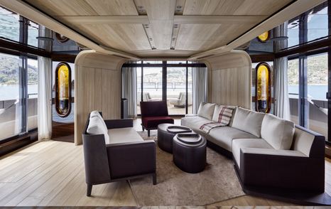 Main salon on board Sanlorenzo 44 Alloy. White and dark brown sofas facing over low coffee table, surrounded by full length windows.