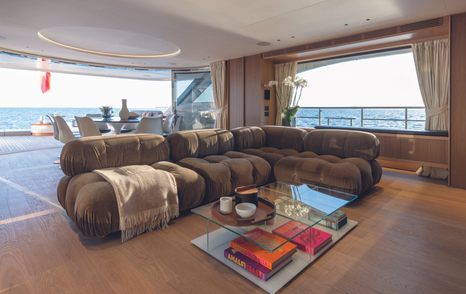 Main salon onboard Oasis 34M, L shaped seating with aft opening to exterior decks in the background.