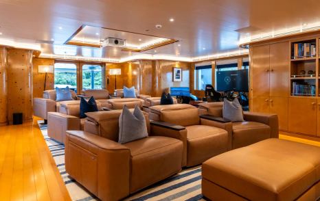 Superyacht Rocinante's cinema room with plush brown sofas 