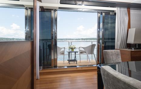 Motor yacht Lady J main saloon fold out balcony with chairs and glass sliding doors 