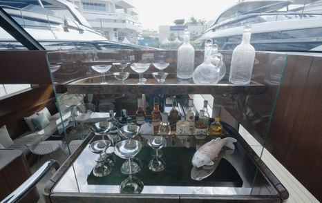 Bar cabinet in the Sanlorenzo SHE saloon with glassware and dark wood finish