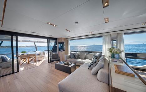 Motor yacht Spica's saloon L-shaped sofa and sliding glass doors