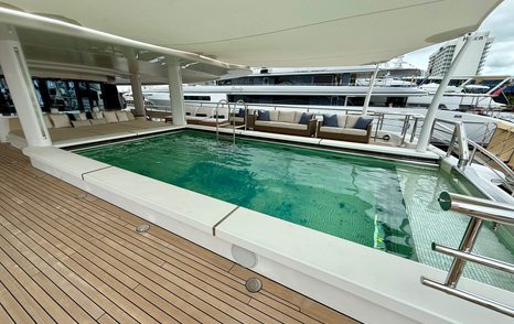 Pool deck on the Amels 242 Casino Royale with shaded seating areas and large rectangular swimming pool.