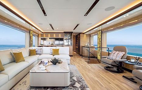 Rear view of Horizon Yachts FD102 lounge area on main deck, L shaped sofa with coffee table, overlooking wide windows