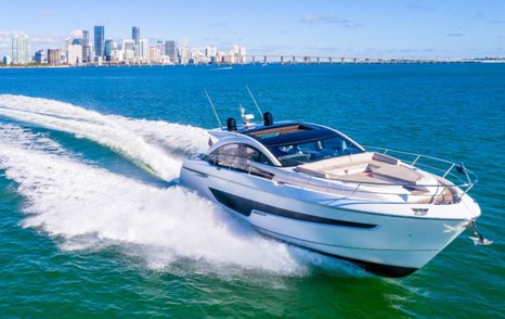 Fairline Targa 65 GT underway, with skyscrapers in far distance.