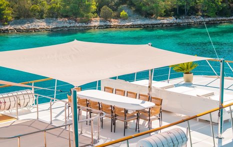 Superyacht Victory's sundeck alfresco dining with shade from canopy