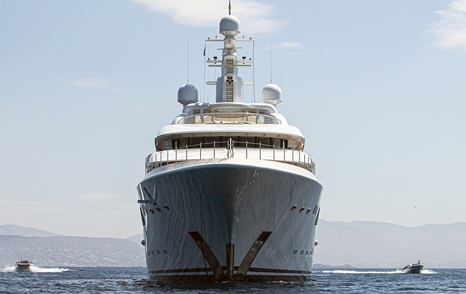 Frontal view of Meridian A underway, surrounded by sea with tenders travelling along on both sides.