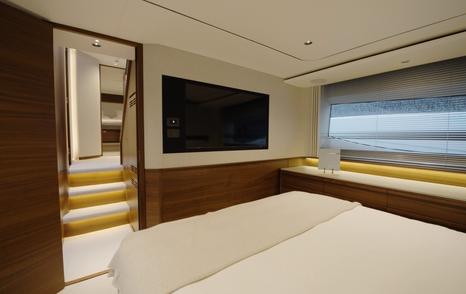 Princess S65 Mk2 owner's cabin with wall-mounted TV and steps to the en suite