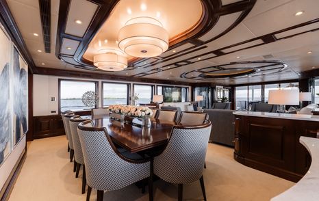 Superyacht Summer Dance main saloon dining area with wooden table and grey chairs