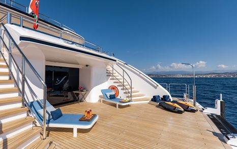 Beach club area onboard superyacht SOARING, sunloungers and water toys on swim platform, surrounded by the sea.