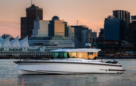 Chase boat on calm water with skyscrapers in background