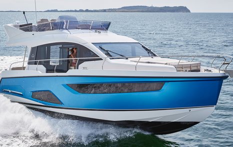 Front view of Sealine F430 underway, with Owner at helm. Surrounded by water.