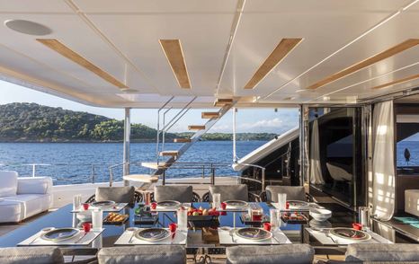 Custom Line Navetta 42 superyacht aft deck shaded alfresco dining and stairs to port