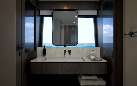 Ensuite bathroom on motor yacht Ferretti 800 with marble basin, mirror and sea views 