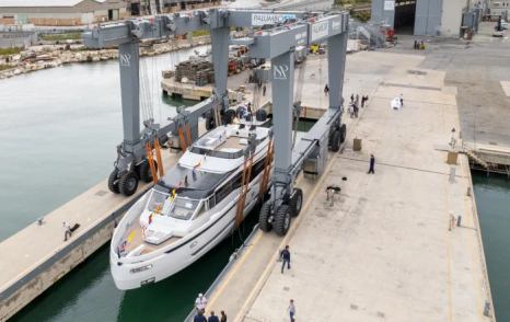 Overview of Extra X99 Fast being launched in dock, being lowered by a crane on to the water.