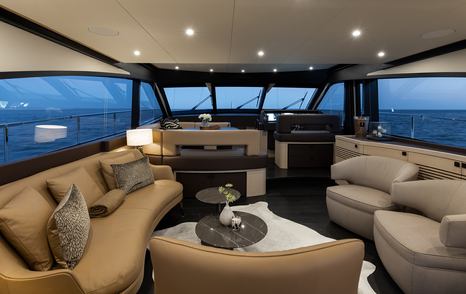 Mulder Favorite 2200 motor yacht salon with curved beige seating and low lighting