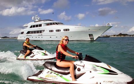 two charter guests on PWC in front of superyacht on anchor