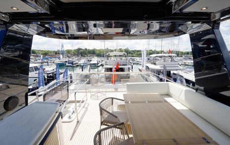 Beneteau Grand Trawler 63 flybridge entertaining area with outdoor dining table and sheltered seating