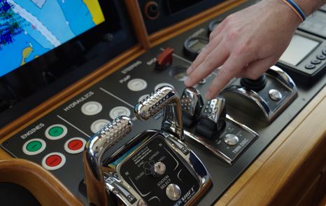Fleming 85 polished metal engine throttles and helm controls at the lower steering station