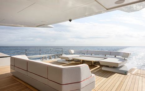 Alia Superyacht Ximena main bridge aft deck with U-shaped white sofas while under way 