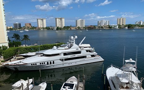 Close up view of superyachts moored at Boca Raton Resort & Club Marina – Boca Raton. Skyscrapers and sea in background