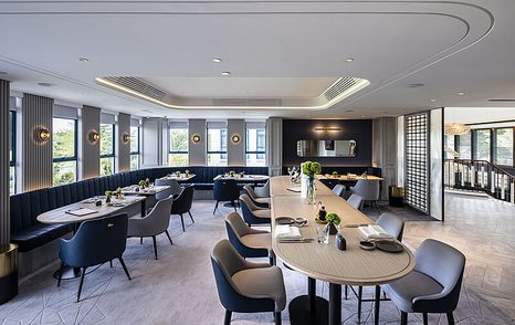 Overview of Lantau Yacht Club dining area. Long stretching tables and place settings with windows reaching all round exterior walls.