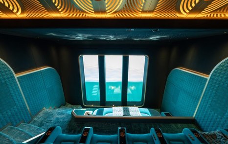 Teal themed interior cinema with plush raised seating onboard motor yacht KISMET