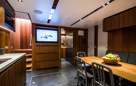 Inside galley onboard YXT 24 Evolution, with dining table on starboard side and kitchen facilities to port