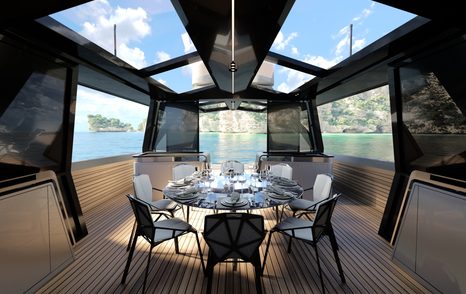 Overview f Wally WHY100 looking out aft past dining area. Extended swim platform visible in background with cliff faces seen outside.