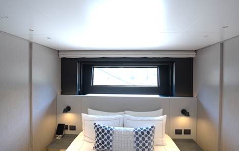 Benetti Oasis 34M double guest cabin showing storage, bedside lighting and hull window detail.