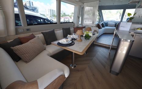 Dining and seating area inside the Galeon 620 Fly saloon with large side windows and residential styling.