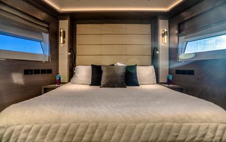 Motor Yacht Saint guest cabin with double bed, modern wood finishes and ambient lighting