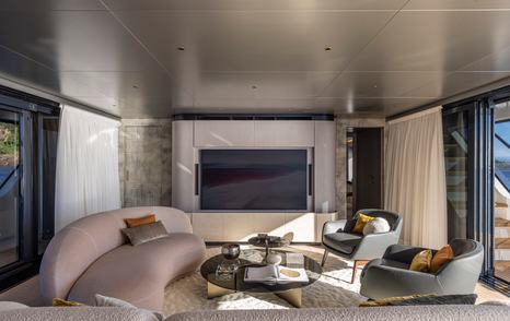 Fourth 29m Arcadia A96 Yacht main saloon with mounted Tv and curved seating
