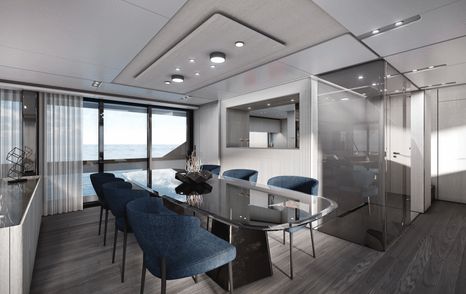 Overview of Ferretti 1000 interior dining area, with glass table an blue chairs, large windows stretching across far side.