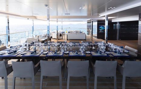 Dining option onboard superyacht BOLD, dining table and chairs overlooking views on aft deck.