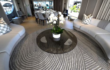 Benetti Oasis 34M saloon lounge with curved sofa seating, coffee table and floor-to-ceiling glazing.