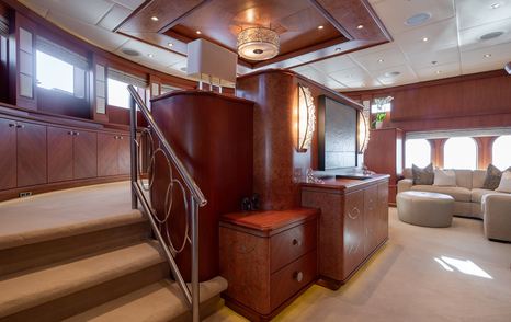 Superyacht Skyfall lower level master cabin with curved seating and pop up TV