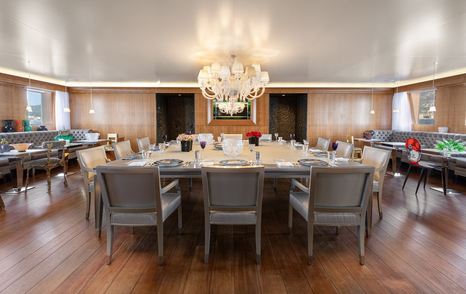 Wedge Too yacht dining room with large table and chandelier