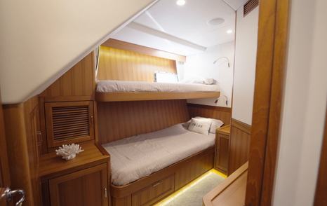 Fleming 85 guest cabin with upper and lower bunks and integrated storage