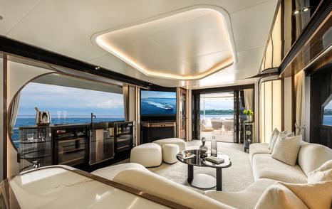 Horizon FD100 Skyline motor yacht main salon with curved white seating and glass coffee table 