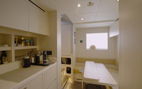 Crew mess aboard the Gulf Craft Majesty 145 with dining table, pantry and crew kitchenette