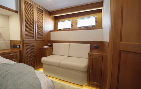 Fleming 85 owner's cabin lounge area with hull windows and extensive storage