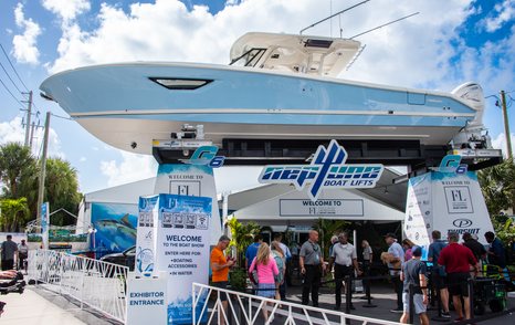 Overview of FLIBS exhibitors with a boat elevated over visitors exploring the exhibition ground