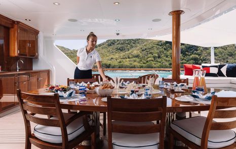 Chief stewardess laying dining table on yacht