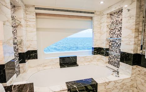 Ensuite bathroom on motor yacht W with marble bathtub with sea views