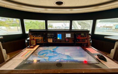 Wheelhouse helm station on the Amels 242 Casino Royale with panoramic bridge windows.