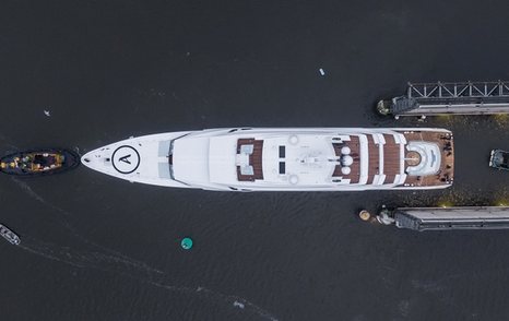 Aerial view of Lurssen 'Project Hawaii' leaving dock, helipad seen on the foredeck.